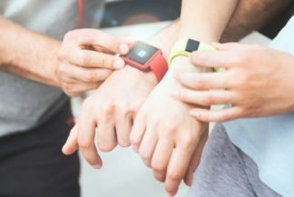 Sporty couple using their red and green Fitbits
