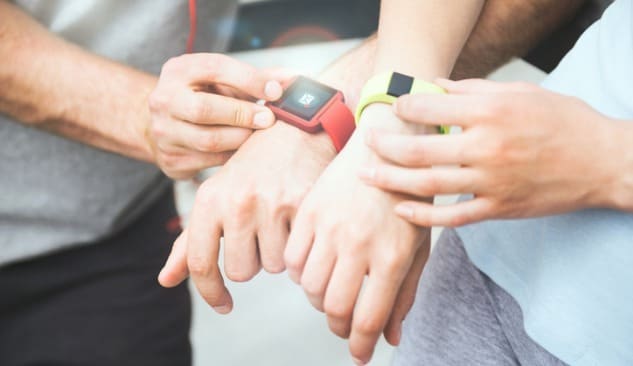Sporty couple using their red and green Fitbits