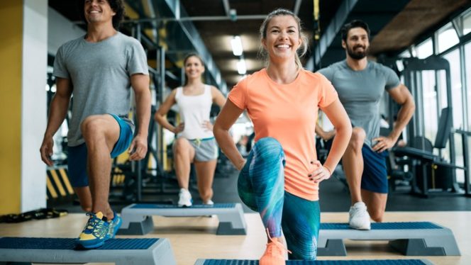 smiling people exercising at the gym