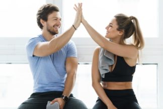 Two people high fiving after achieving their fitness goals